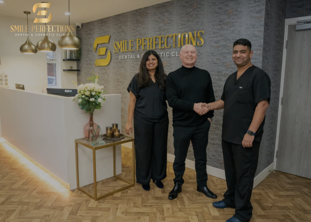 Dr Pratima and Dr Juttes Pallipatt with a patient in the reception area at Smile Perfections - Dr Juttes shaking hands with the patient - all 3 smiling